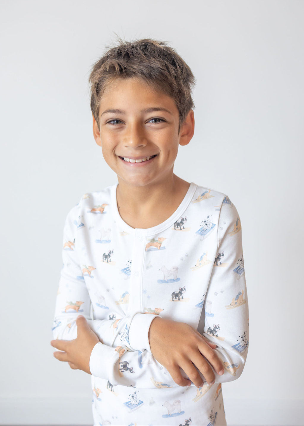 Young boy wearing a long-sleeve shirt with animal print on a white background