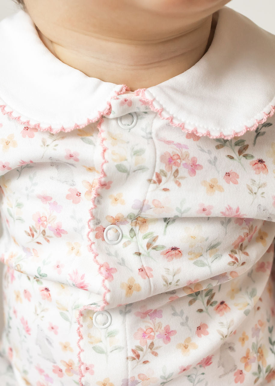 Close-up of a baby's floral outfit with a soft focus on the face.