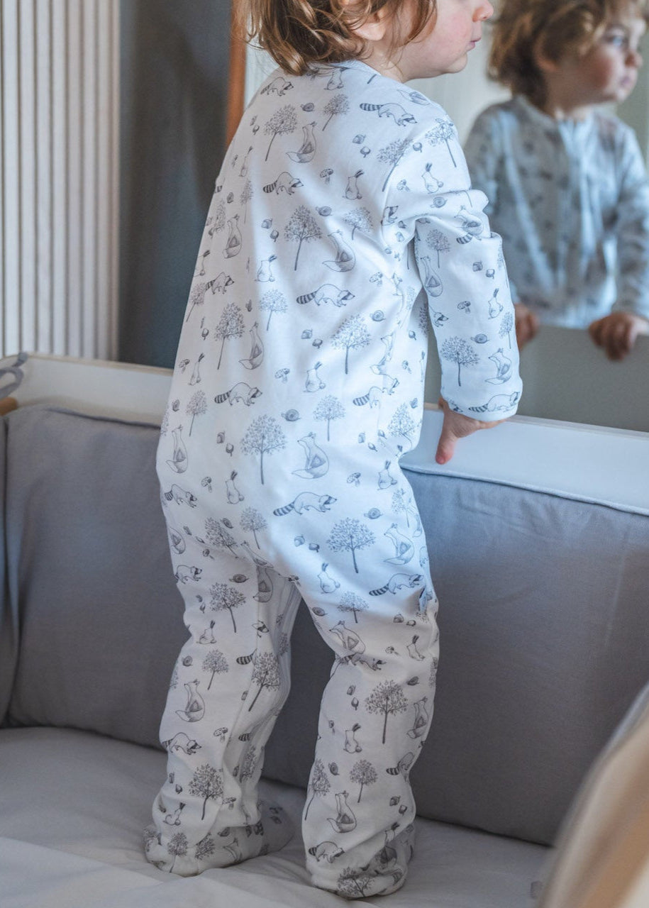 Child in a crib looking at themselves in a mirror