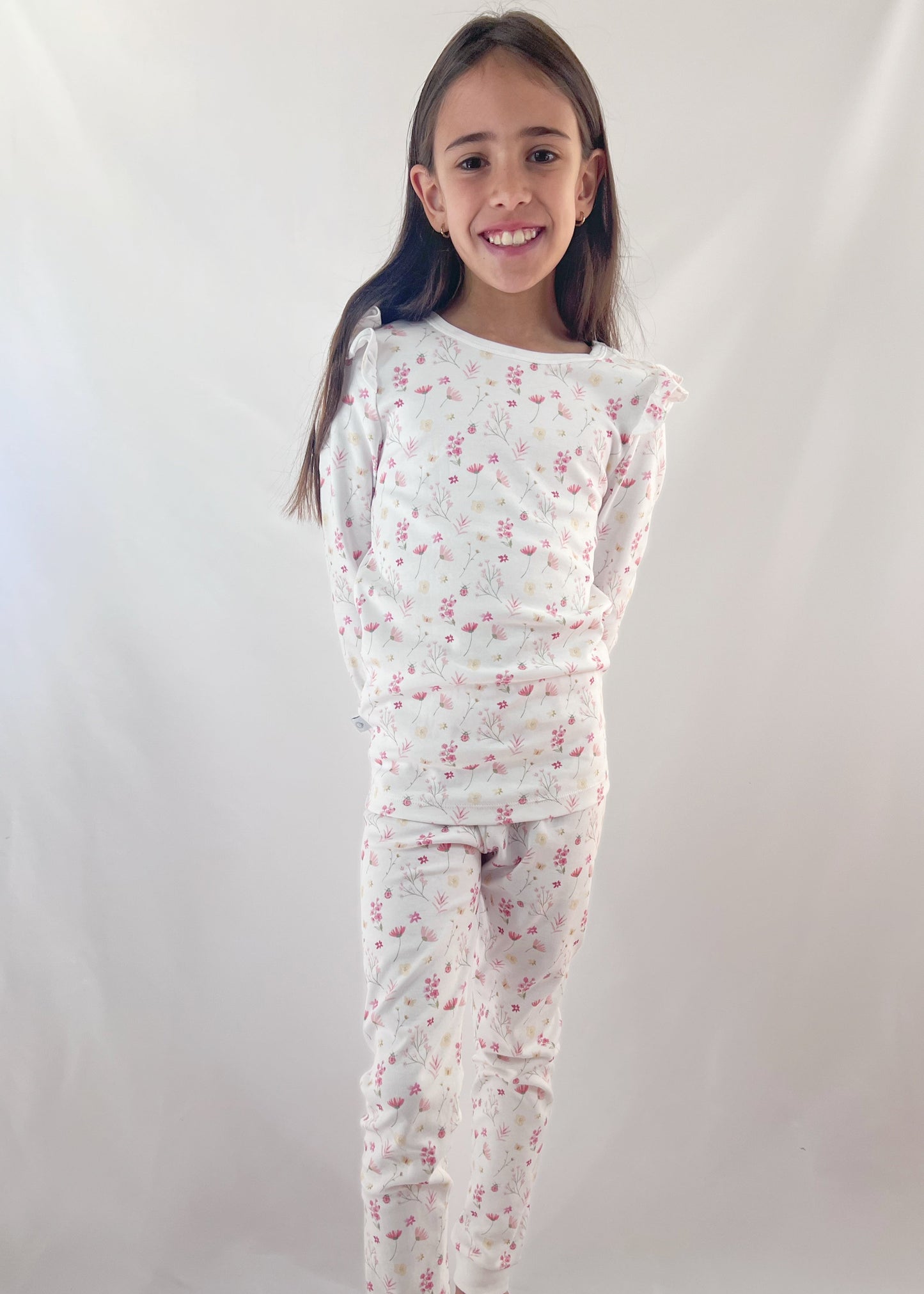 Young girl wearing a floral pajama set on a white background