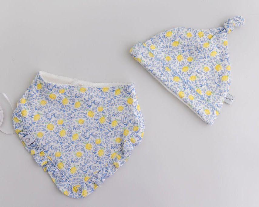 Baby bib and hat set with floral pattern on a gray background